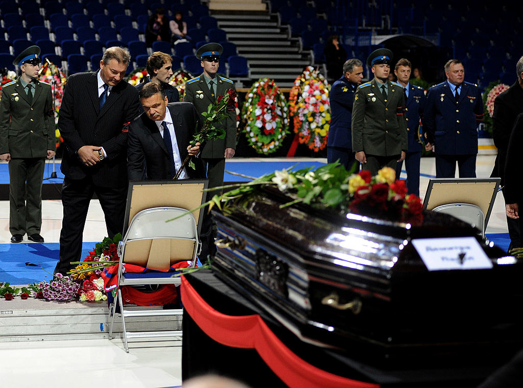 IIHF:n puheenjohtaja Rene Fasel ja pelaajalegenda Vladislav Tretjak laskemassa ruusuja menehtyneen pelaajan arkulle.